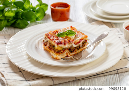 portion of Lasagna on white plate, top view 99898126