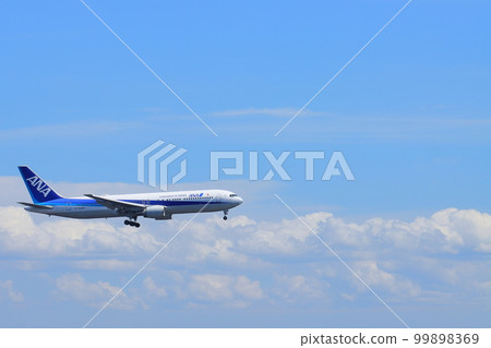 Passenger plane flying in the summer sky: Passenger plane approaching landing 99898369