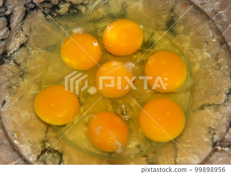 Seven raw eggs in a clear bowl Seven raw eggs in a clear bowl 99898956