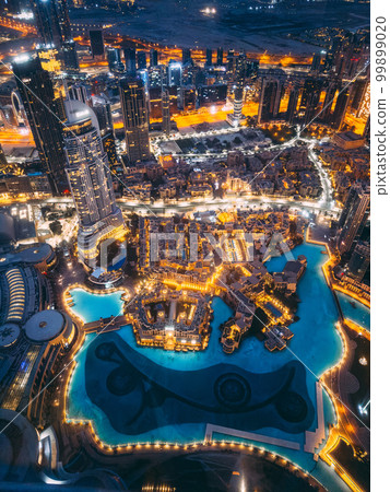Aerial view of Downtown Dubai with roads, Dubai Mall and the fountain by night, from Burj Khalifa 99899020