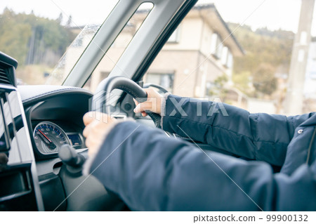 Middle-aged woman's hand holding the steering wheel Middle-aged woman's hand holding the steering wheel 99900132