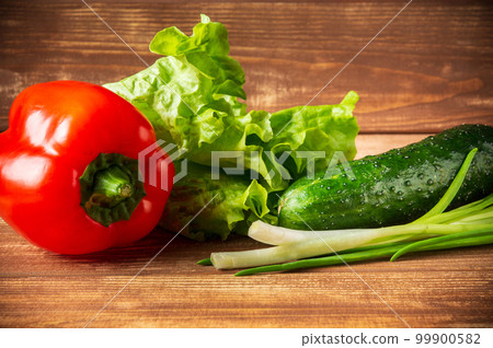 A set for preparing a salad of fresh herbs, cucumbers and red peppers on vintage table closeup. Diet Idea A set for preparing a salad of fresh herbs, cucumbers and red peppers on vintage table closeup. Diet Idea 99900582