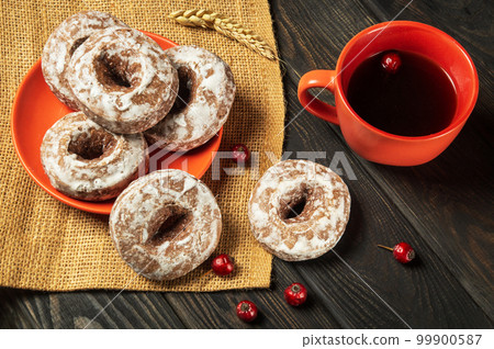 Homemade round gingerbread cookies with icing in a plate and hot rosehip tea. Idea for a delicious breakfast or dinner Homemade round gingerbread cookies with icing in a plate and hot rosehip tea. Idea for a delicious breakfast or dinner 99900587