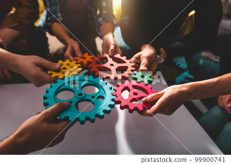 Teamwork of business people work together and combine pieces of gears 99900741
