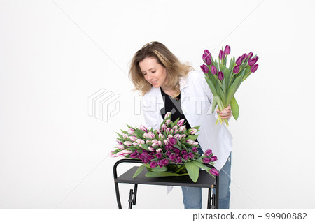 A sweet girl collected a bouquet of different varieties of tulips. Stands on a white background A sweet girl collected a bouquet of different varieties of tulips. Stands on a white background 99900882