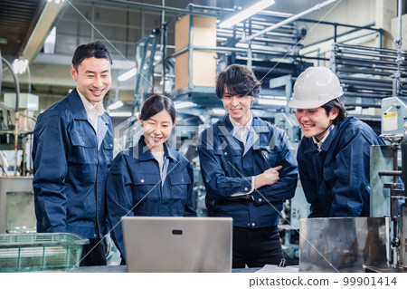 Factory staff discussing while looking at a computer Factory staff discussing while looking at a computer 99901414