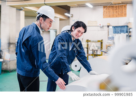 A worker checking roll paper in a printing factory 99901985