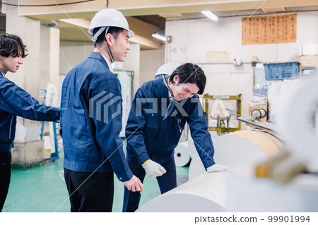 A worker checking roll paper in a printing factory 99901994