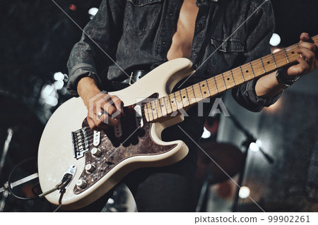 Close-up of rock musician guitarist playing the electric guitar on stage Close-up of rock musician guitarist playing the electric guitar on stage 99902261
