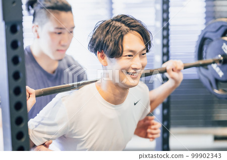 Young man training hard with trainer Young man training hard with trainer 99902343