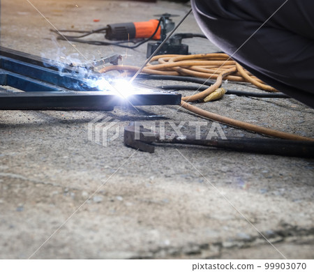 The welder is welding the steel structure to add to the house 99903070