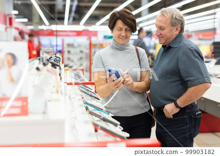 Elderly man and elderly woman choose mobile phone 99903182