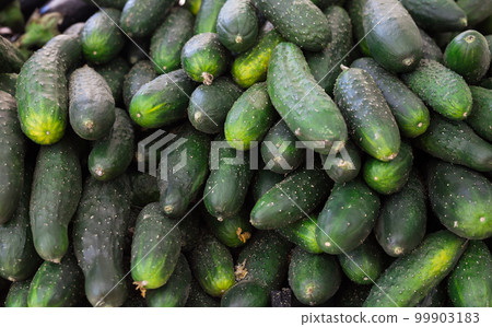 cucumbers on market counter in wicker basket 99903183