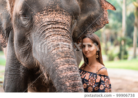 portrait of a girl next to an elephant.close up portrait of a girl next to an elephant.close up 99906738