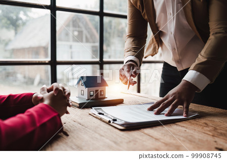 Close up Business people or Real Estate agent explain signing agreement for sale house to client. Property, Insurance, Broker concept Close up Business people or Real Estate agent explain signing agreement for sale house to client. Property, Insurance, Broker concept 99908745