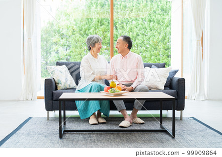 Senior couple relaxing on the sofa Senior couple relaxing on the sofa 99909864