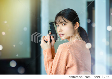 A woman with a gun 99911286