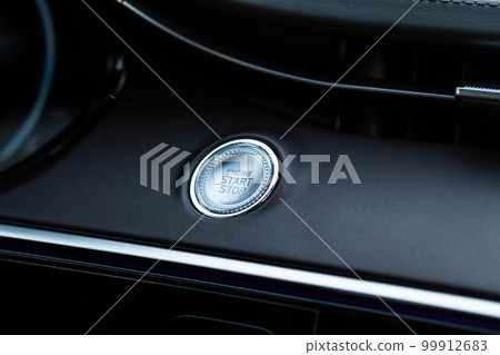 Engine start button. Close up engine car start stop button. Modern car interior details. 99912683