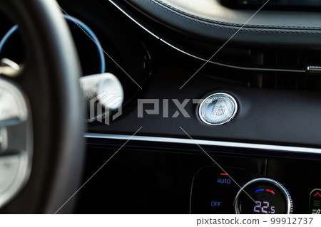 Engine start button. Close up engine car start stop button. Modern car interior details. 99912737