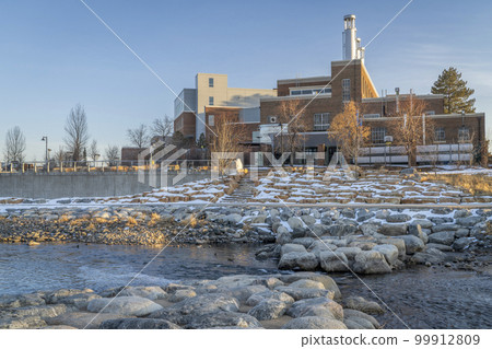 Poudre River at a whitewater park in downtown of Fort Collins Colorado with Powerhouse Energy Campus of Colorado State University in background, winter sunset scenery Poudre River at a whitewater park in downtown of Fort Collins Colorado with Powerhouse Energy Campus of Colorado State University in background, winter sunset scenery 99912809