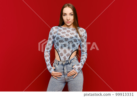 Confident young woman on red wall background Confident young woman on red wall background 99913331