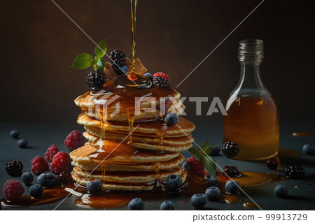 Scene of pouring maple syrup on delicious pancakes and lots of berries 99913729