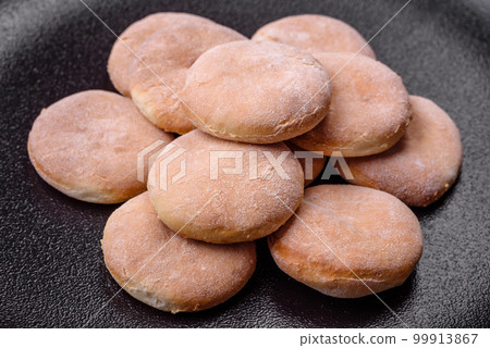 Delicious fresh baked cornmeal shortcakes or cookies on a black plate 99913867