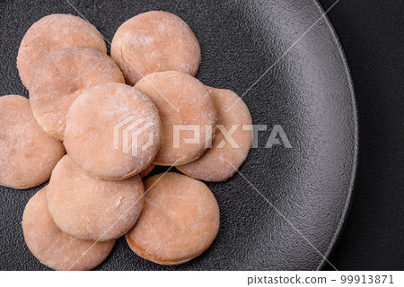 Delicious fresh baked cornmeal shortcakes or cookies on a black plate 99913871