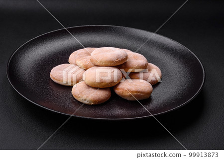 Delicious fresh baked cornmeal shortcakes or cookies on a black plate 99913873