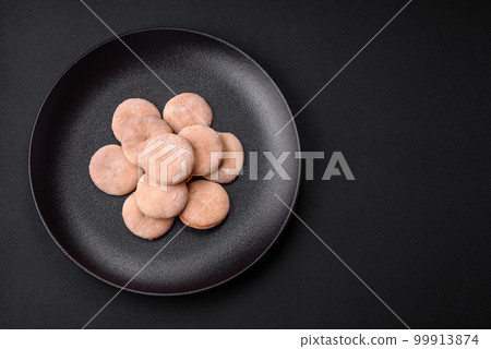 Delicious fresh baked cornmeal shortcakes or cookies on a black plate 99913874