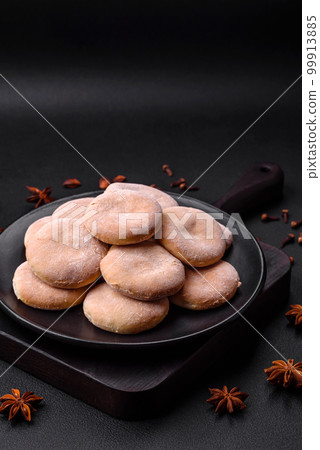 Delicious fresh baked cornmeal shortcakes or cookies on a black plate 99913885