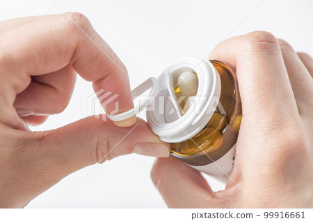 Antidepressants, taking pills for depression and disorders of the central nervous system. A woman's hand opens a bottle of antidepressants close-up on a white background. 99916661