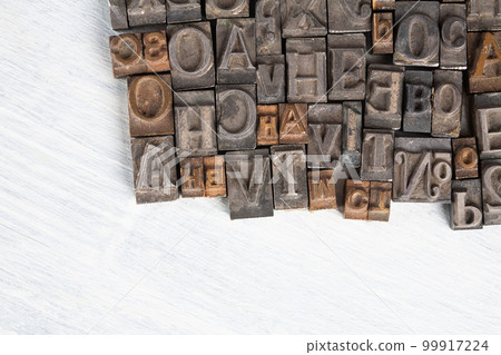 Antique vintage movable type alphabet set on white wooden deck Antique vintage movable type alphabet set on white wooden deck 99917224