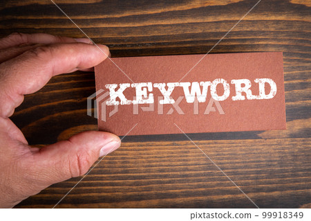 KEYWORD. Text on brown paper. Wood texture background 99918349