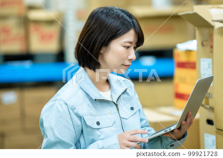 Female staff who manages inventory at the warehouse Female staff who manages inventory at the warehouse 99921728