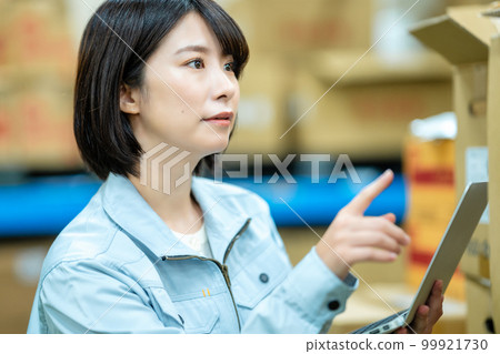 Female staff who manages inventory at the warehouse Female staff who manages inventory at the warehouse 99921730
