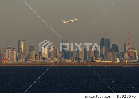An airplane taking off with Tokyo skyscrapers in the background 99923670