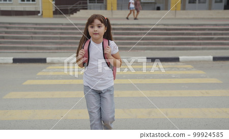 girl child goes through pedestrian crossing. happy student with school backpack. zebra road. child girl crosses road zebra. pedestrian traffic sign. road rules. girl child goes from lessons classroom girl child goes through pedestrian crossing. happy student with school backpack. zebra road. child girl crosses road zebra. pedestrian traffic sign. road rules. girl child goes from lessons classroom 99924585