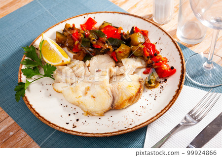 Close up of mediterranean shark steak on white plate on blue tablecloth Close up of mediterranean shark steak on white plate on blue tablecloth 99924866