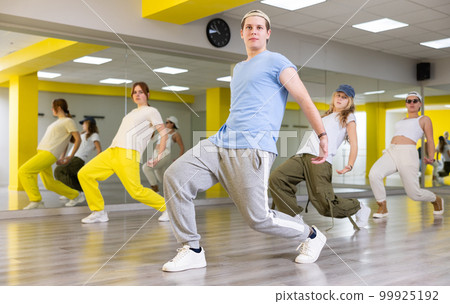 Teenage boy training breakdance Toprock moves in dance hall 99925192