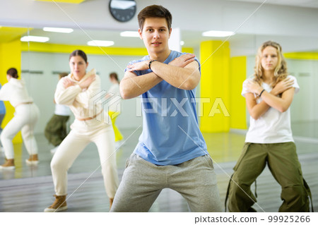 Young guy dancing modern dance in studio 99925266