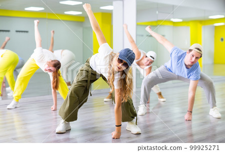 Teenage girl training breakdance drops in dance hall Teenage girl training breakdance drops in dance hall 99925271