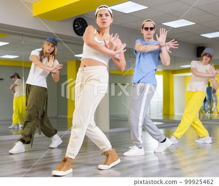 Teenages hip hop dancers doing dance workout during group class Teenages hip hop dancers doing dance workout during group class 99925462