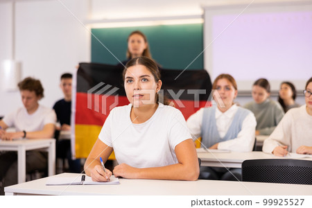 Teacher stands behind students with German flag 99925527