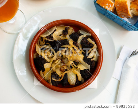 Delicious Catalan blood sausages with grilled onion served on plate. Morcilla con cebolla Delicious Catalan blood sausages with grilled onion served on plate. Morcilla con cebolla 99925558