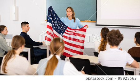 Female professor shows students flag of USA Female professor shows students flag of USA 99925562