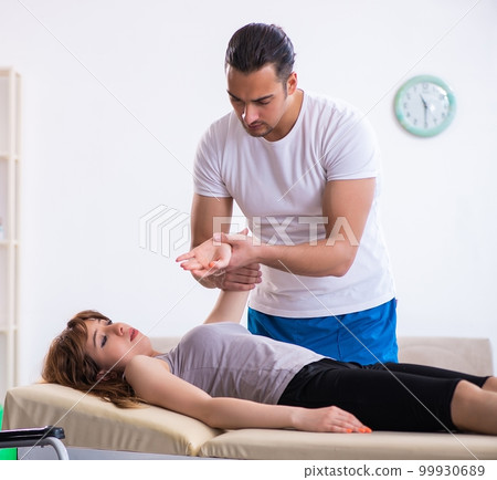 Young woman visiting male doctor physiotherapist 99930689