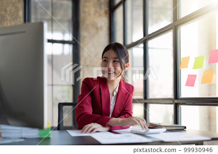 businesswoman working on desk office with using a calculator to calculate the numbers, finance accounting concept businesswoman working on desk office with using a calculator to calculate the numbers, finance accounting concept 99930946