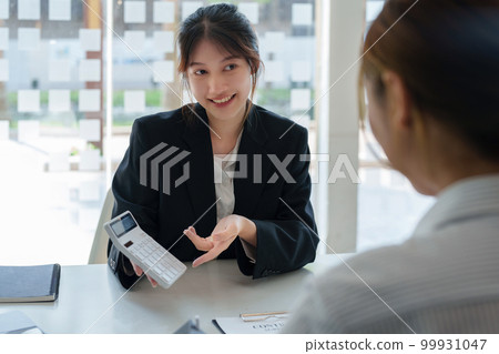 Guarantee, mortgage, contract, contract, signed, real estate agent or bank officer holding a calculator, submits a bid with a customer to buy a home before signing to make a deal. Guarantee, mortgage, contract, contract, signed, real estate agent or bank officer holding a calculator, submits a bid with a customer to buy a home before signing to make a deal. 99931047