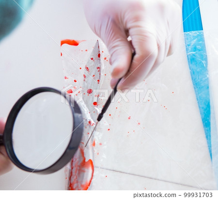 Criminologist police chemist looking at crime evidence 99931703